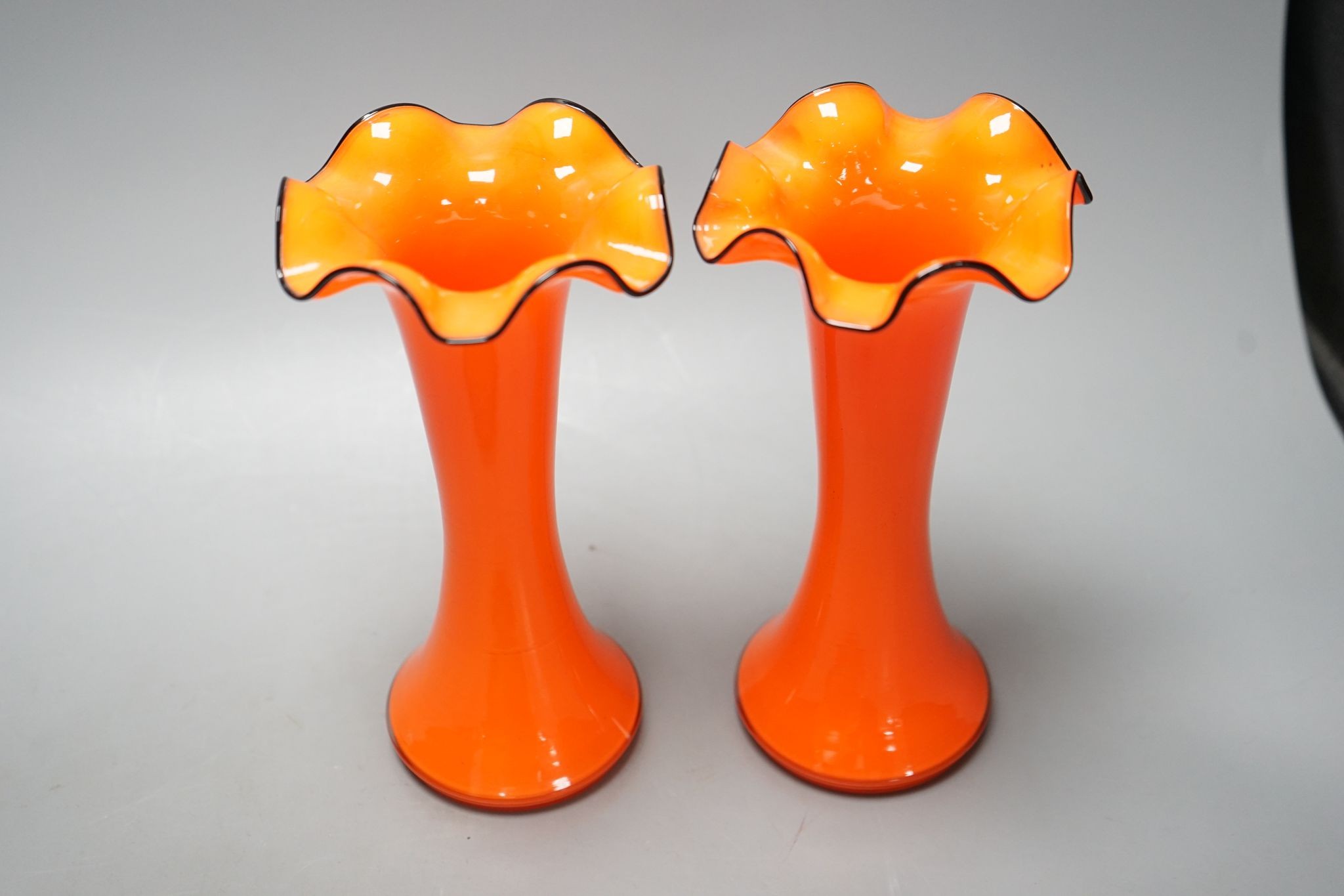 A tangerine glass bowl with silver plated mount to rim and a pair of spill vases, in the style of Michael Powdry, tallest 21cm